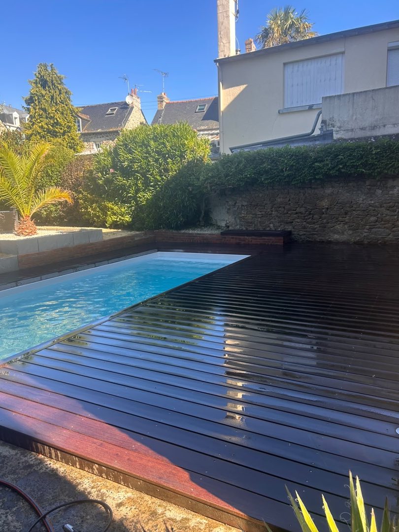 Après nettoyage – Terrasse en bois exotique autour d’une piscine à Rennes : le bois grisé par les UV retrouve sa teinte chaude et profonde.